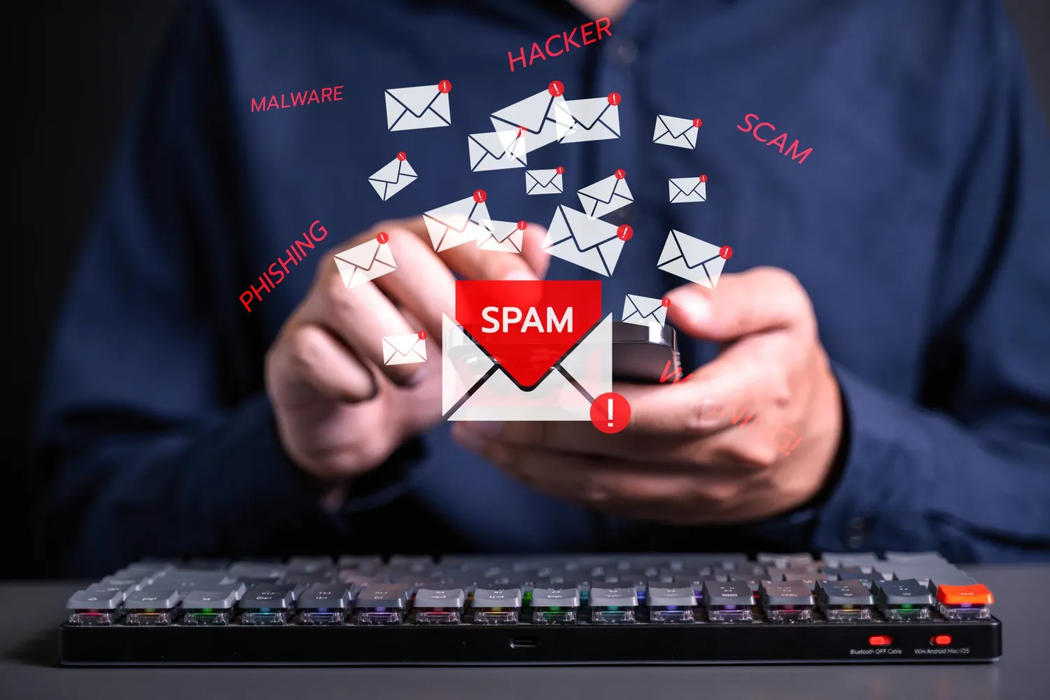 En strøm av e-poster velter opp av en mobiltelefon, merket med ordene spam, phishing, hacker, malware og scam.